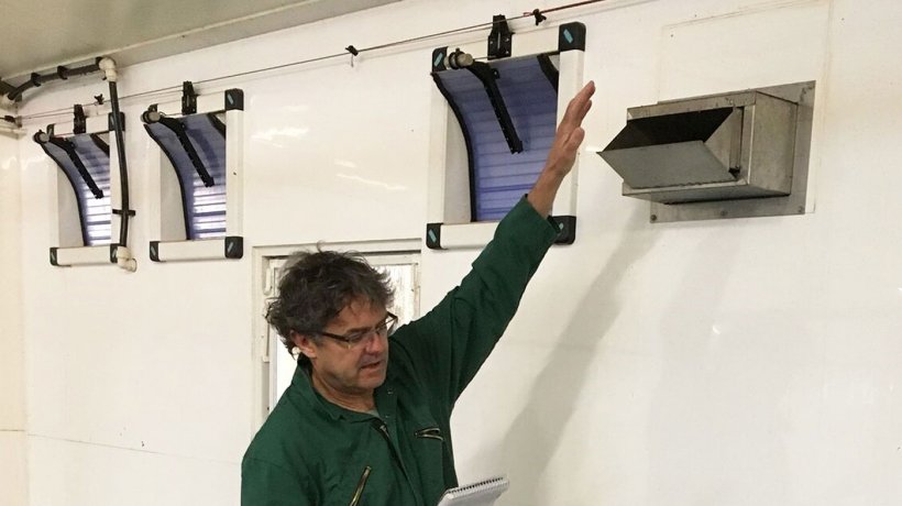 Tim Miller checks a heated air inlet in a weaner-grower house.
